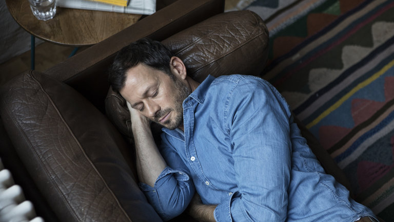 Apneia causa cansaço: Homem dormindo no sofá