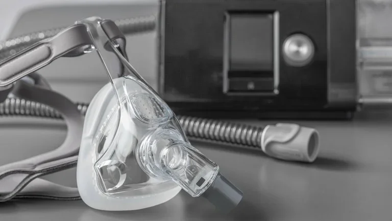 Máscara de apneia do sono CPAP na mesa cinza