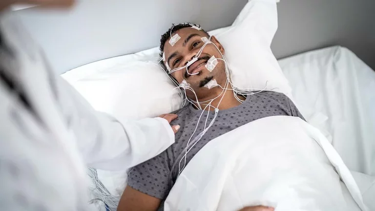 Homem realizando exame de polissonografia para diagnóstico do sono.