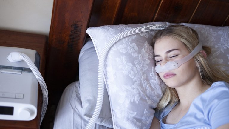 Homem adormecido com problemas crônicos de respiração considera usar máquina CPAP na cama
