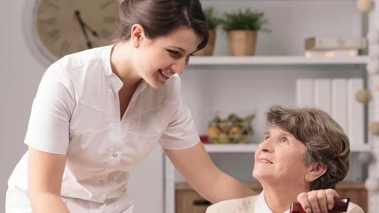 Cuidadora auxiliando a paciente em casa