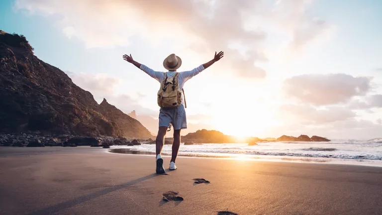 Braços de jovens estendidos pelo mar ao nascer do sol desfrutando de liberdade e vida, as pessoas viajam conceito de bem-estar