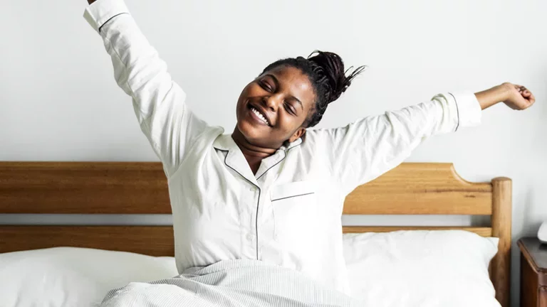 Mulher acordando feliz após uma boa noite de sono