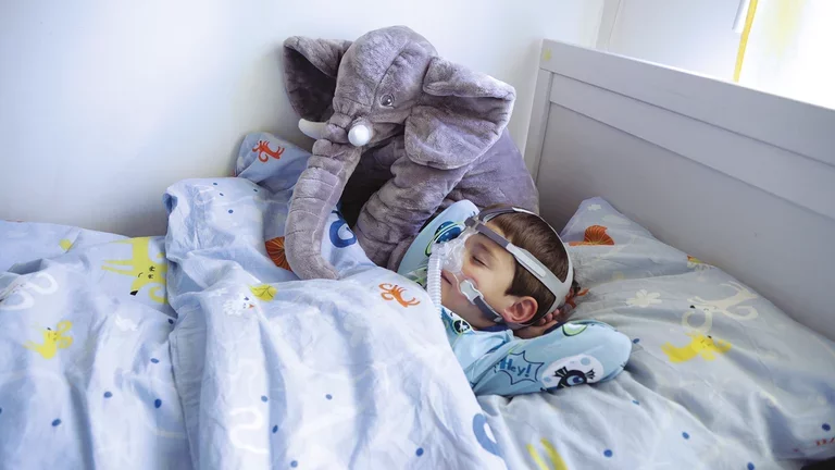 Criança dormindo com máscara nasal  da marca Air Liquide Medical System- ALMS