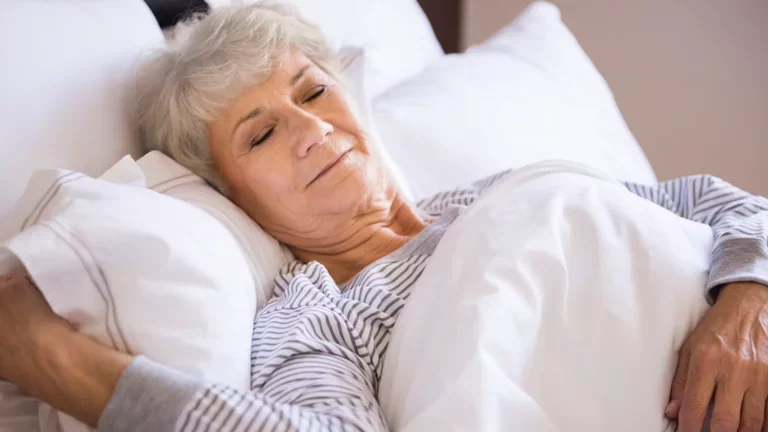 Mulher idosa dormindo em sua cama bem confortável