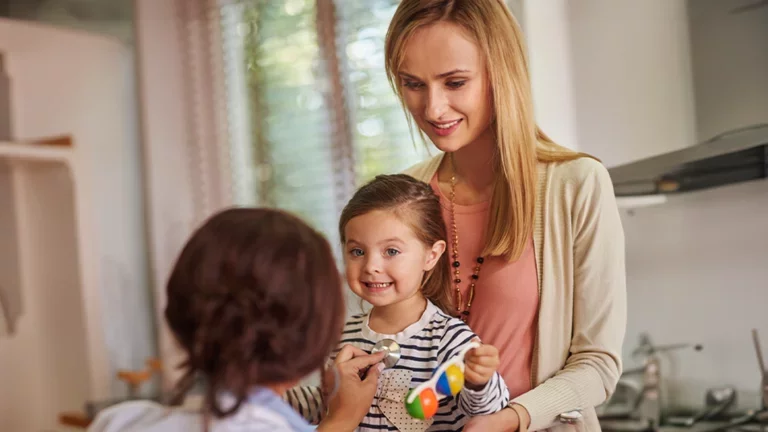 Criança sorrindo no colo da mãe em consulta médica