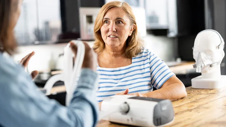 Mulher testando o CPAP para apneia do sono com orientação profissional