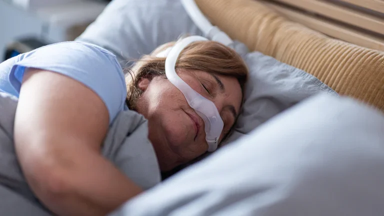 Mulher dormindo confortável com a máscara dreamwear em sua cama
