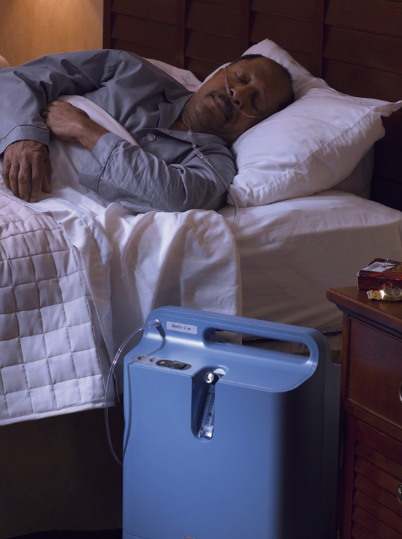 Homem dormindo utilizando concentrador de oxigênio estacionário