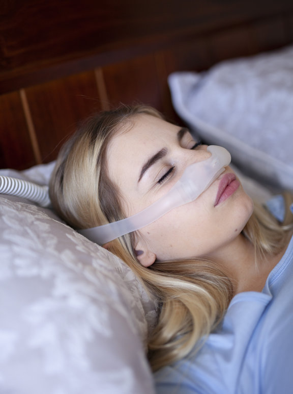 Mulher dormindo com equipamento CPAP