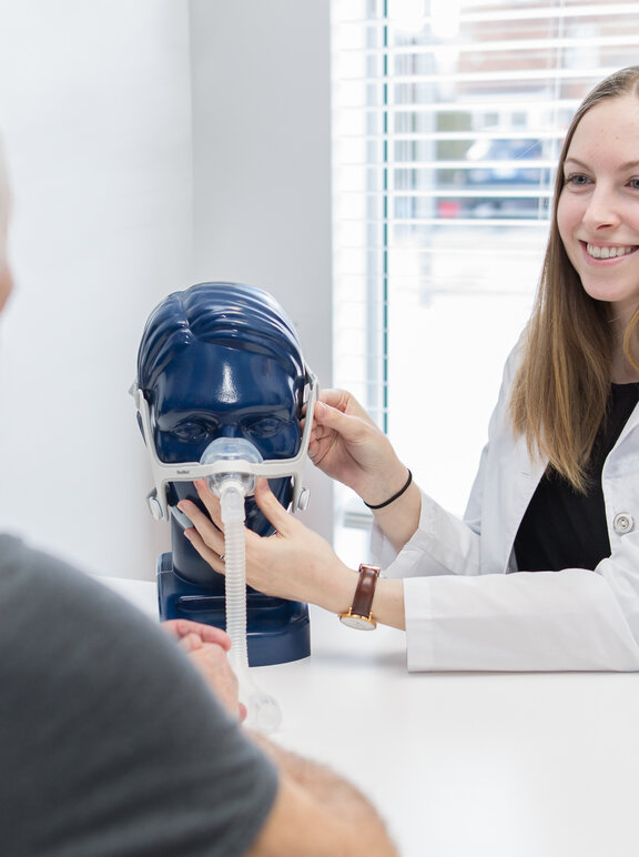 Profissional demonstrando como funciona o equipamento CPAP