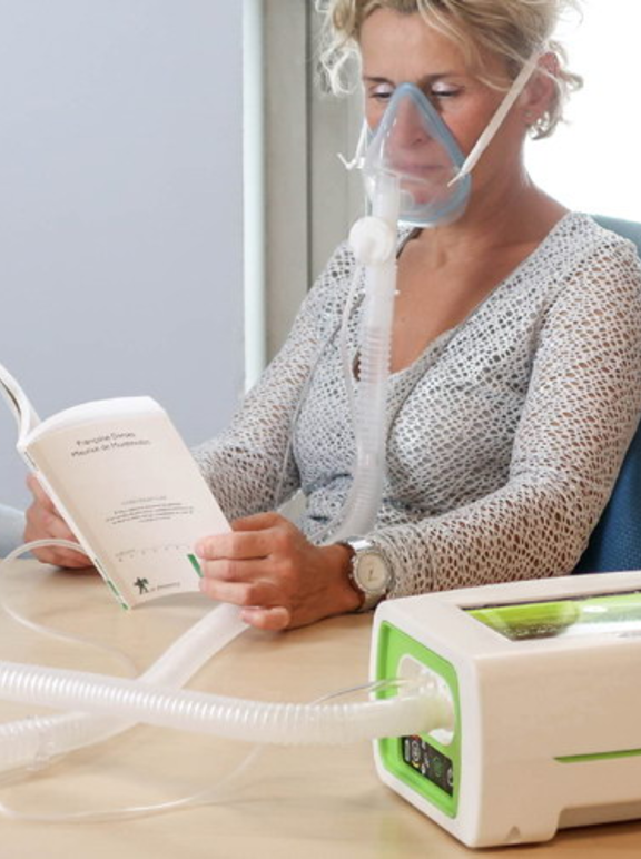 Mulher em ventilação mecânica não invasiva lendo um livro