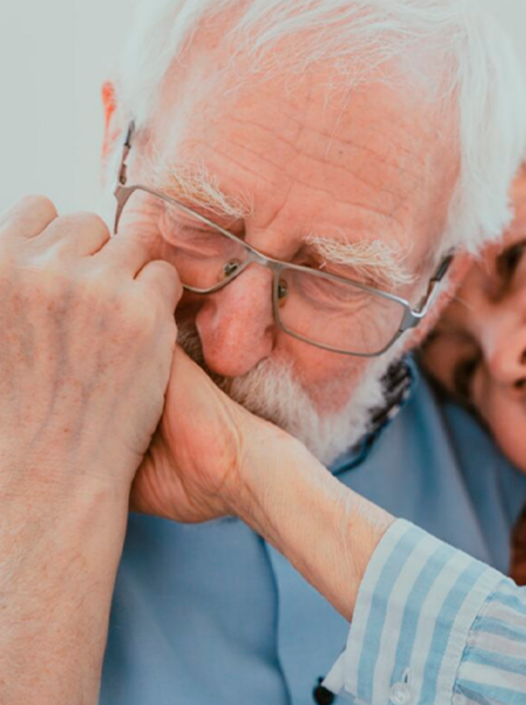 Casal de idosos sentados e abraçados