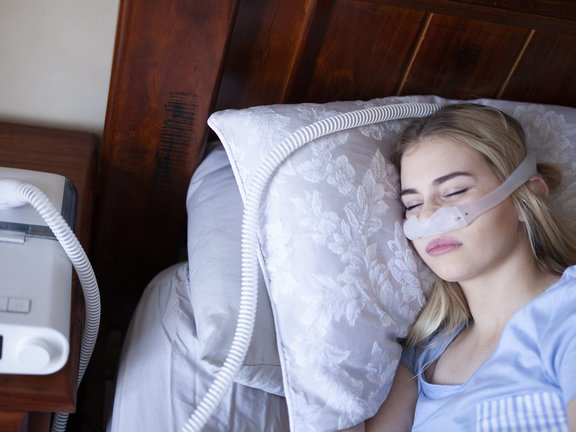 Homem adormecido com problemas crônicos de respiração considera usar máquina CPAP na cama