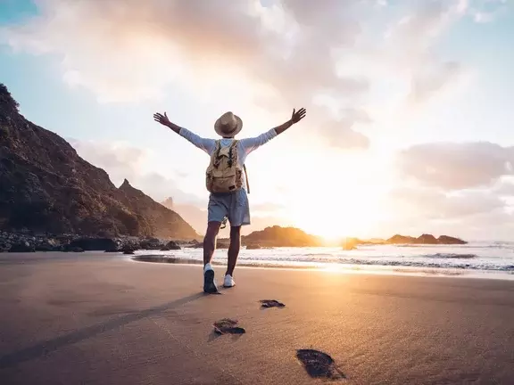 Braços de jovens estendidos pelo mar ao nascer do sol desfrutando de liberdade e vida, as pessoas viajam conceito de bem-estar