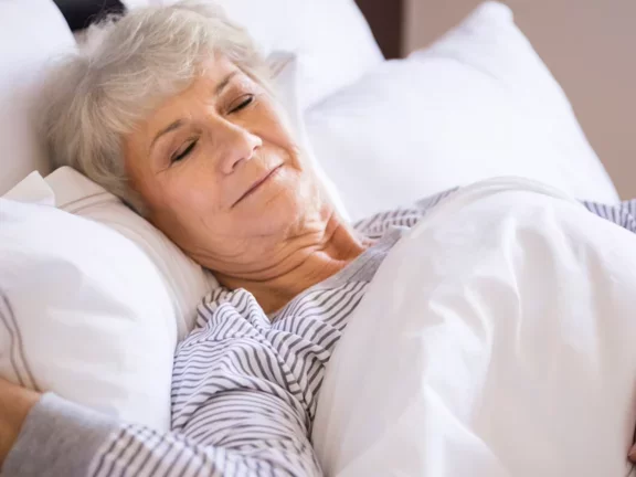 Mulher idosa dormindo em sua cama bem confortável