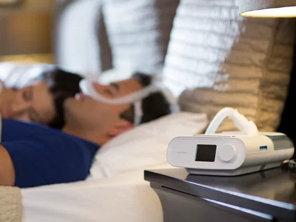 CPAP com umidificador: casal dormindo em sua cama 
