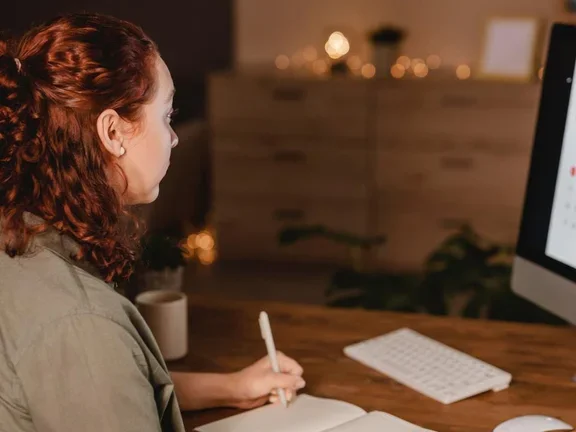 Mulher sentada em sua mesa programando seu próximo pedido online