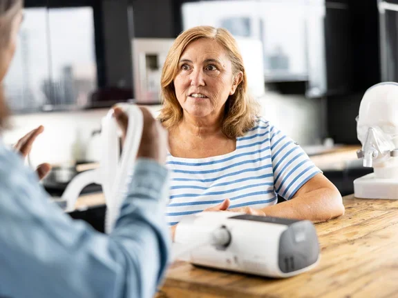 Mulher testando o CPAP para apneia do sono com orientação profissional