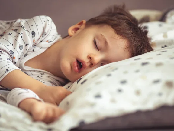 Criança dormindo em sua cama e apresentando ronco 