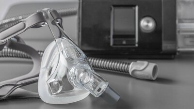 Máscara de apneia do sono CPAP na mesa cinza