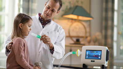 Profissional aplicando terapia com assistente de tosse na criança