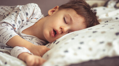 Criança dormindo em sua cama e apresentando ronco 
