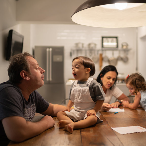 Pais e filhos reunidos na cozinha se divertindo