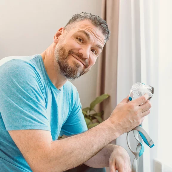 Homem segurando máscara CPAP