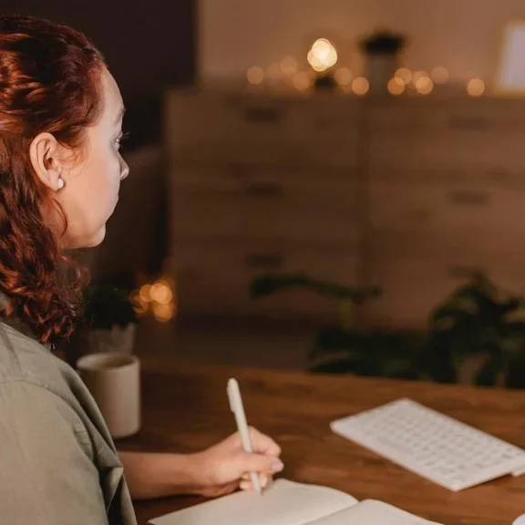 Mulher sentada em sua mesa programando seu próximo pedido online