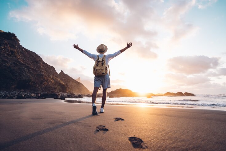 Braços de jovens estendidos pelo mar ao nascer do sol desfrutando de liberdade e vida, as pessoas viajam conceito de bem-estar