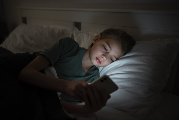 Menino com insônia no celular na hora de dormir