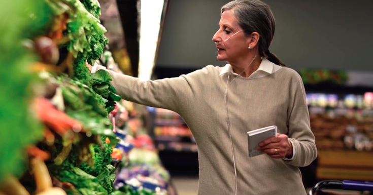 Mulher com oxigênio portátil fazendo compras no supermercado