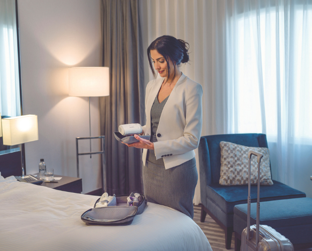 Mulher guardando o seu CPAP portátil na mala de mão