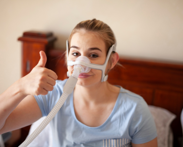 Mulher em uso de máscara nasal e confirmando com o polegar de que está tudo certo